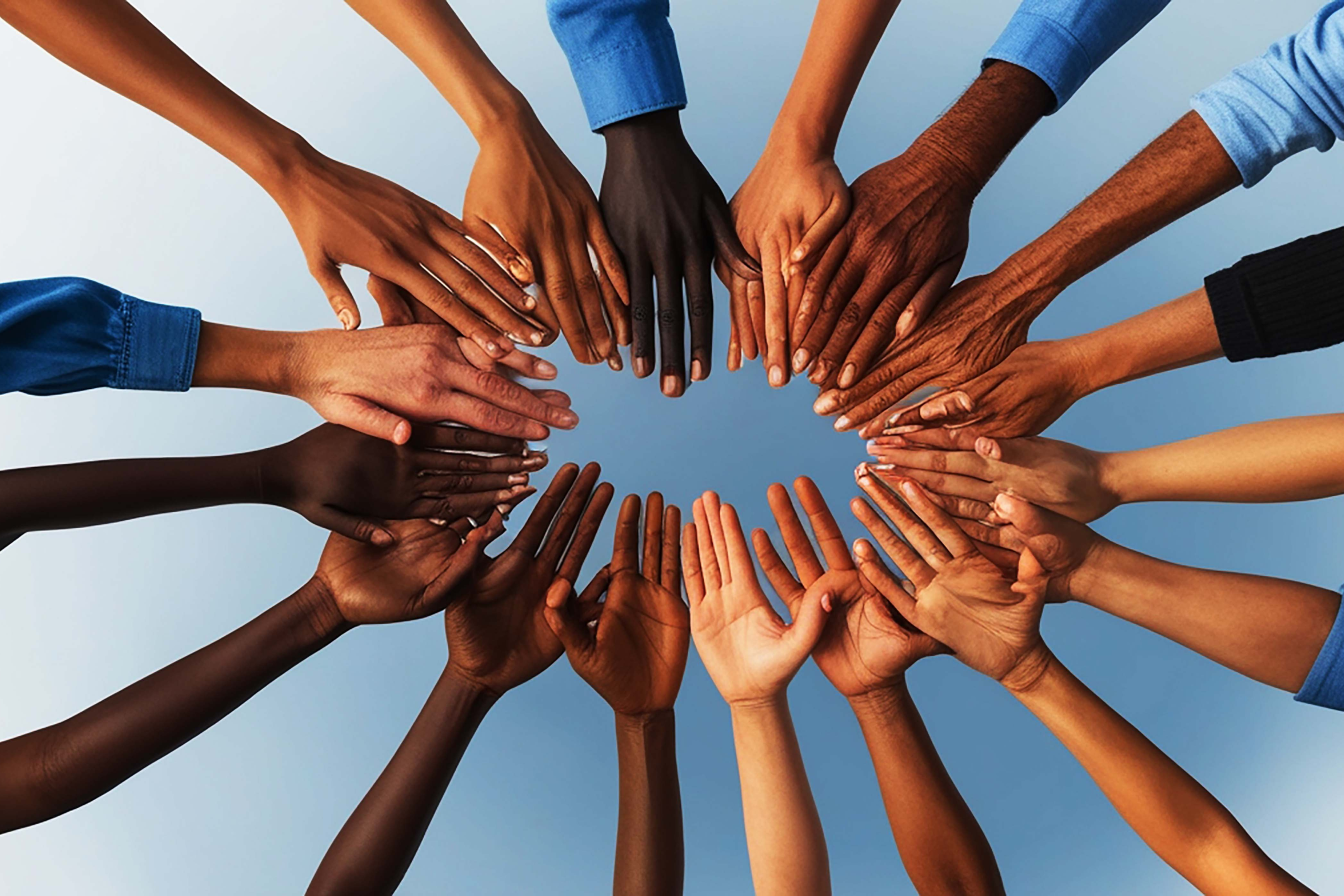 A circle of hands from people of different races and ages.