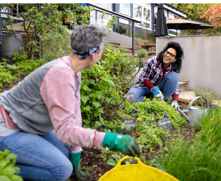 Two women gardening and smiling